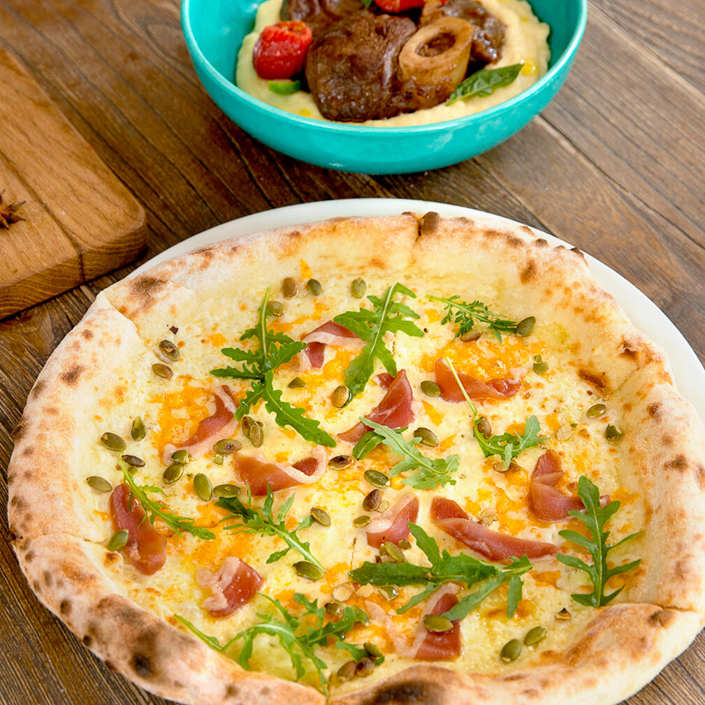 Пицца с сыровяленой уткой, моцареллой, чеддером, сливочным соусом и тыквенными семечками