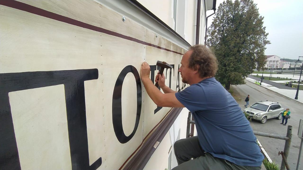 Андрей Кузнецов работает над вывеской